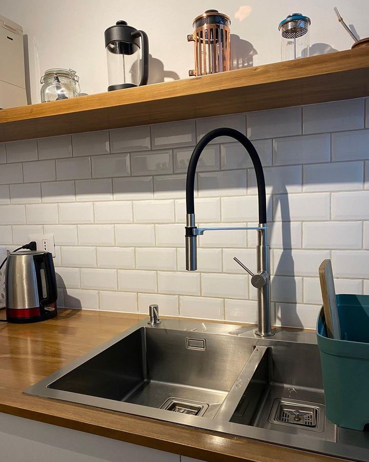 Cocina con revestimiento subway y cubierta de madera