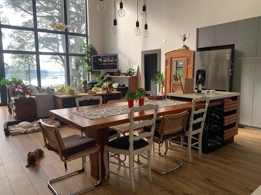 Cocina abierta con ventanal industrial de piso a cielo