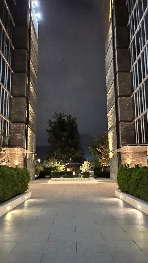 Terraza iluminada de noche con jardín